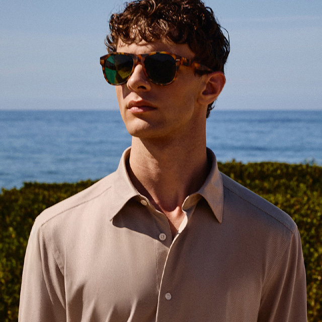 Hellbeiges Herrenhemd, lässig getragen am Strand, mit Sonnenbrille