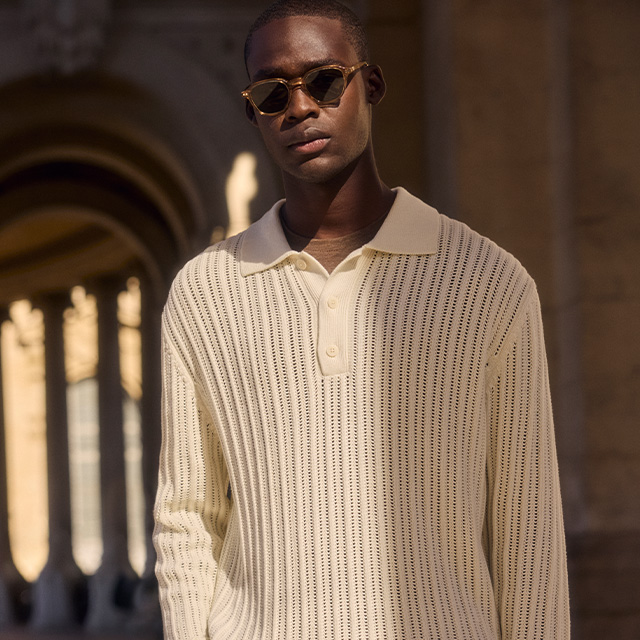 Mann in cremefarbenem Strickpullover mit V-Ausschnitt, lässig getragen