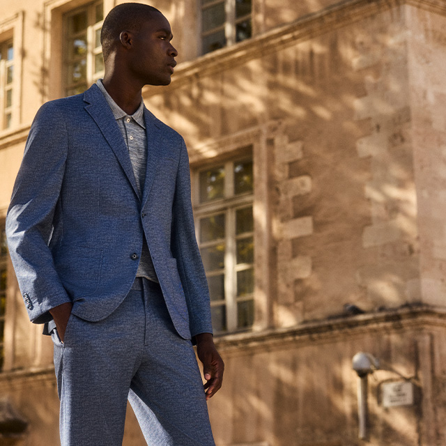 Eleganter grauer Anzug mit passendem Sakko und Hose, getragen über hellgrauem Poloshirt