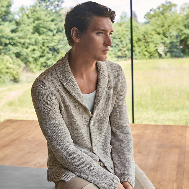 Hellgrauer Strick-Cardigan mit Revers, aus Wolle, getragen über weißem T-Shirt, lässig elegant im Innenraum