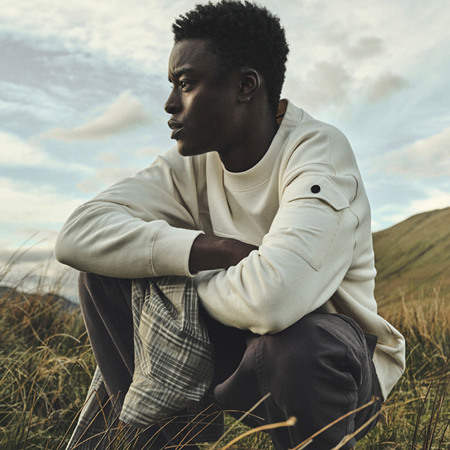 Mann in cremefarbenem Sweatshirt im Freien, lässig getragen