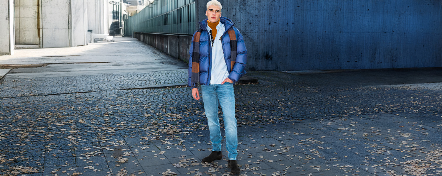 Steppjacke in Blau mit großkariertem Schal, getragen über weißem Hemd und blauer Jeans