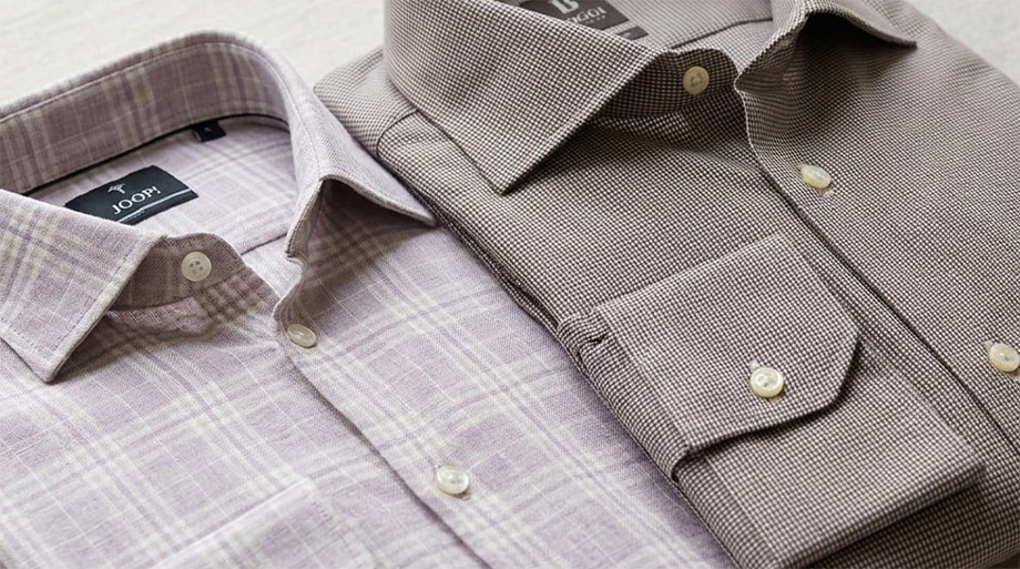 Karierte Business-Hemden in Beige und Braun, klassische Webmuster, sorgfältig gefaltet mit Kragen-Detail