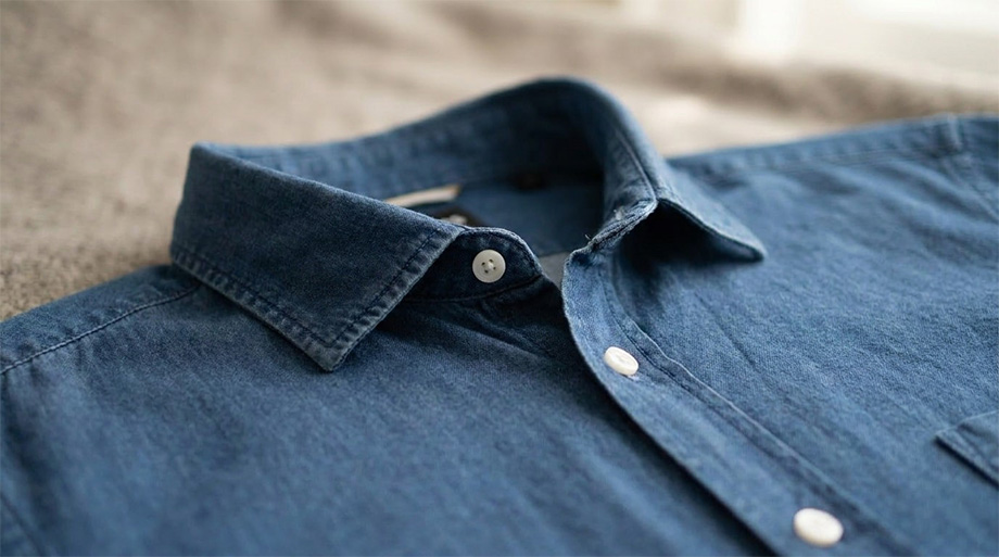 Dunkelblaues Jeanshemd mit Kentkragen und weißen Knöpfen, Nahaufnahme