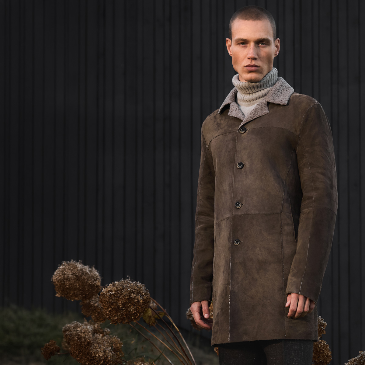 Mann in braunem Lammfell-Mantel mit beigem Rollkragenpullover, Herbst-Wintermode
