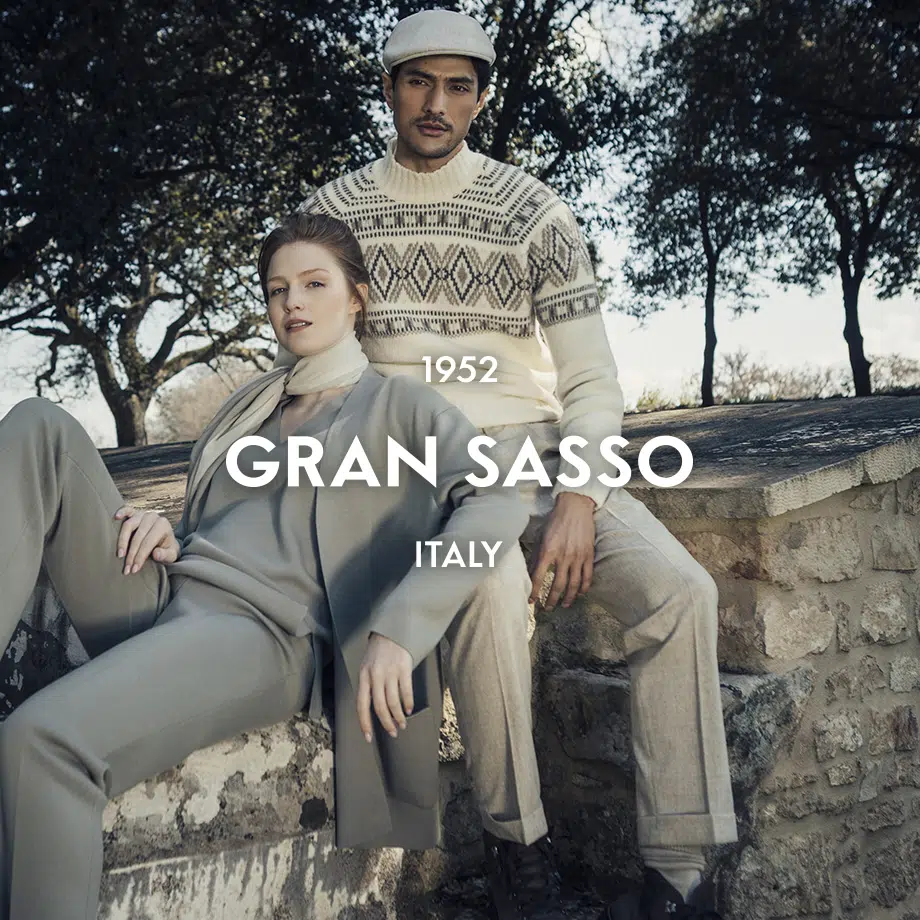 Mann in beigem Strickpullover mit geometrischem Muster und heller Mütze, Outdoor-Shooting in Italien