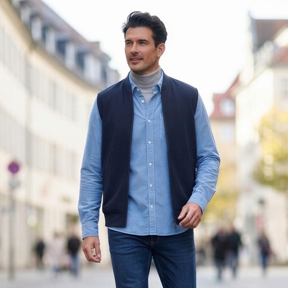 Mann in hellblauem Cordhemd und marineblauer Weste, Smart-Casual-Outfit mit Jeans