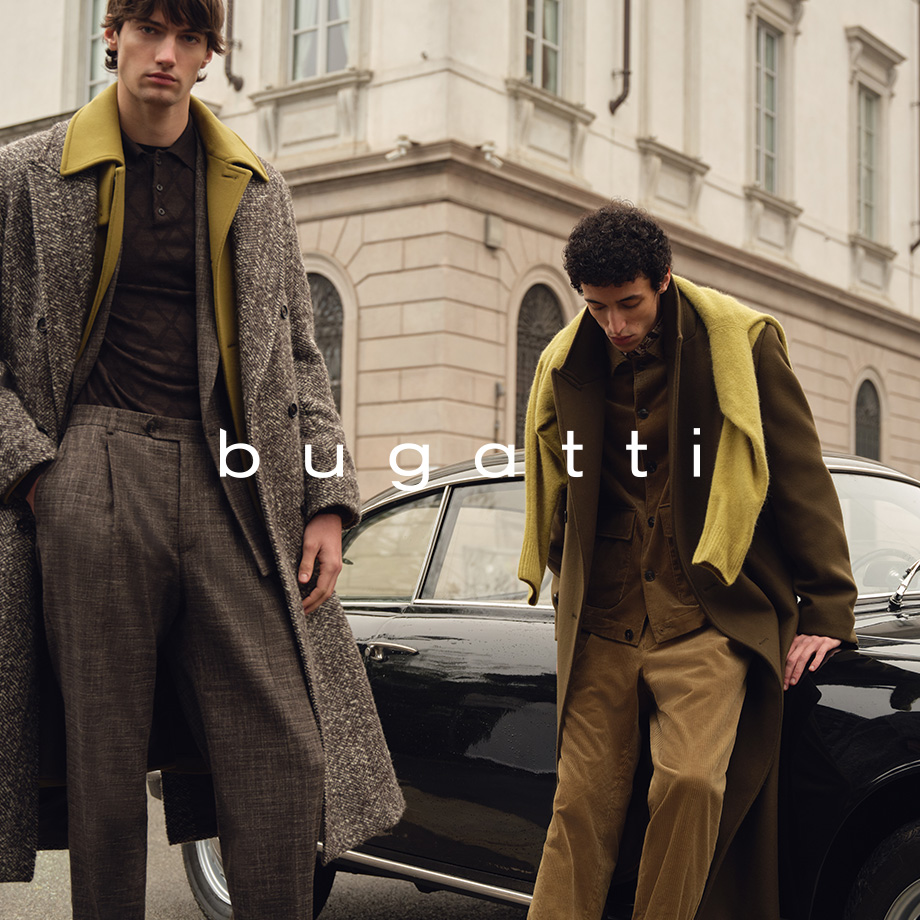 Zwei Männer in Herbst-Wintermänteln mit Poloshirts, klassische Schnitte in Oliv und Braun vor Oldtimer