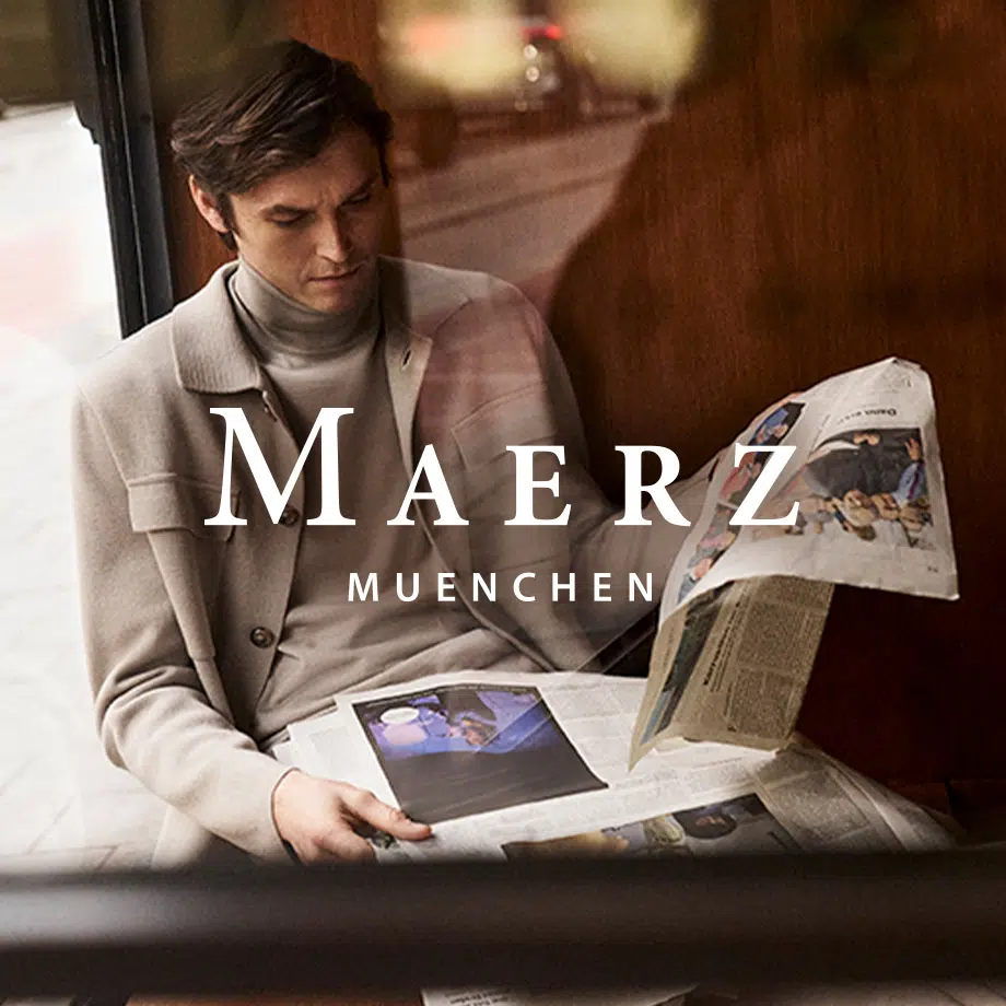 Mann in beigem Wollsakko mit Rollkragenpullover, lesend im Zug, klassischer Business-Casual-Look