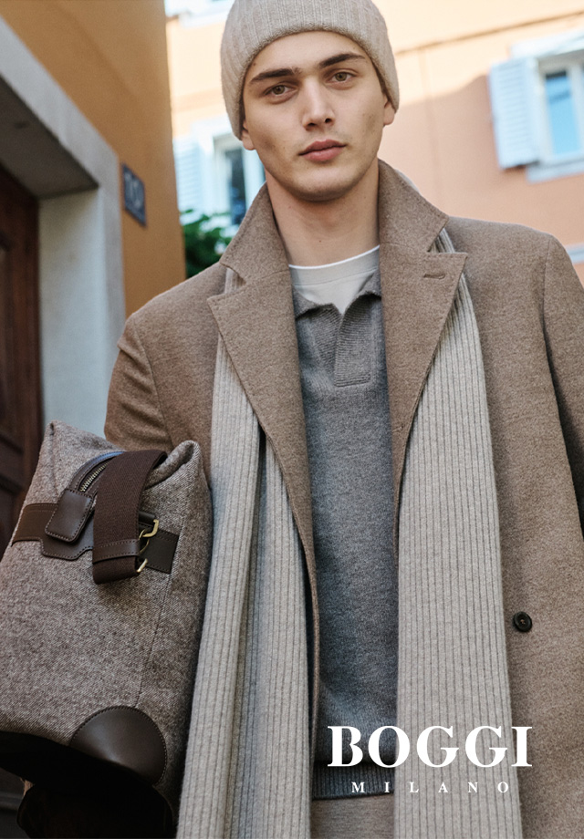 Mann in beigefarbenem Wollmantel mit Strickschal und grauer Strickmütze, Business-Casual-Look im Herbst