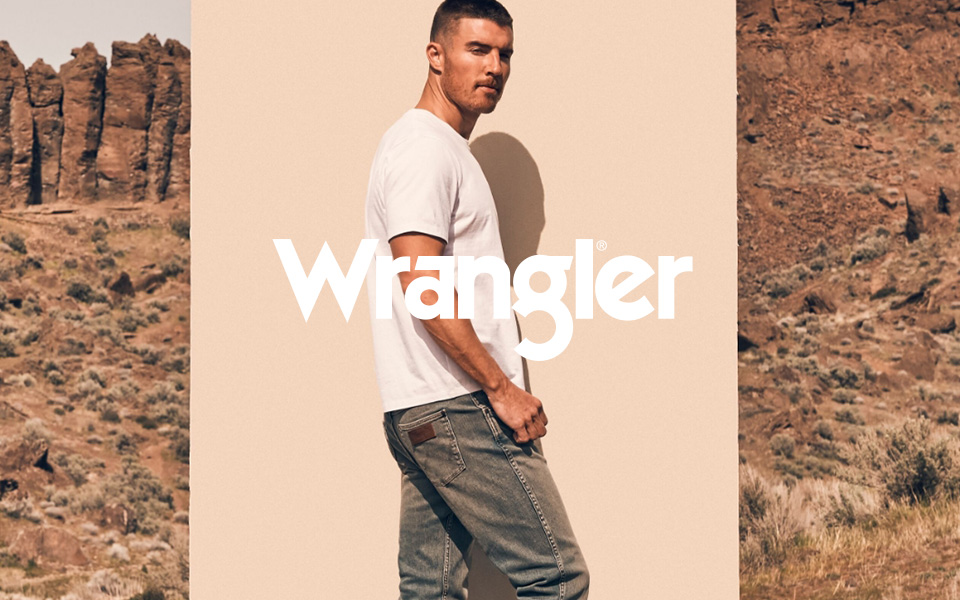 Mann in weißem T-Shirt und blauer Jeans in Wüstenlandschaft