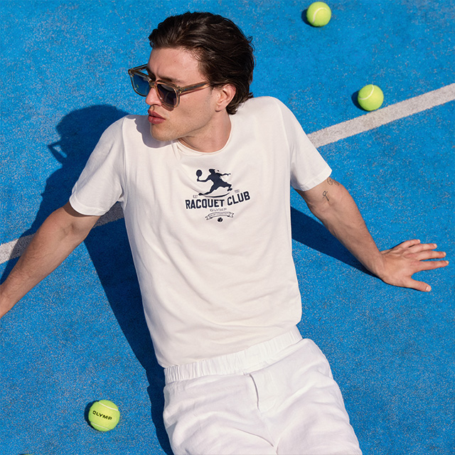 Weißes T-Shirt mit 'Racquet Club'-Print, getragen von Mann auf Tennisplatz