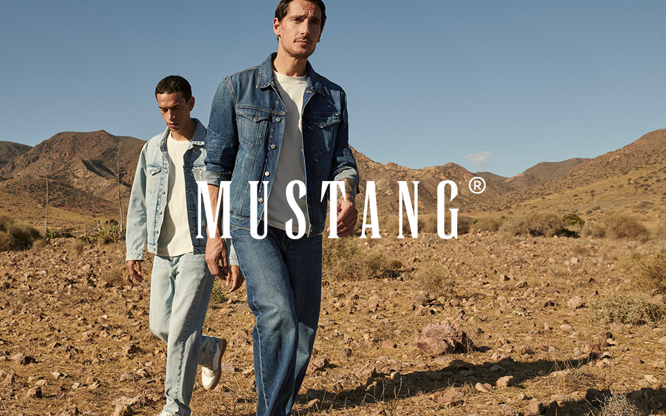 Zwei Männer in blauer und heller Jeansjacke und Jeanshose in Wüstenlandschaft