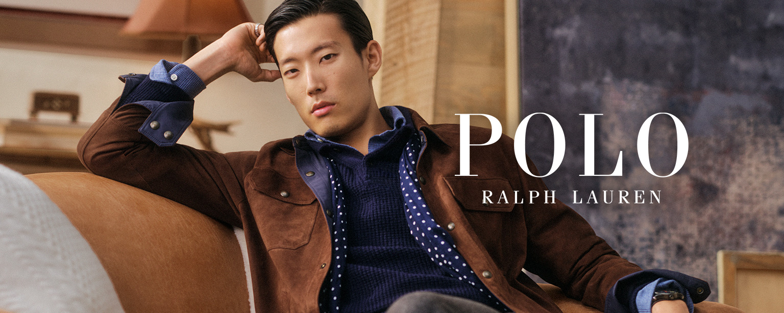 Braune Wildlederjacke mit blauem Hemd, getragen von einem Mann auf einem Sofa