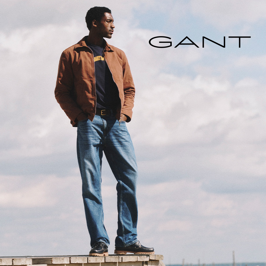 Mann in brauner Jacke und blauer Jeans im Freien, lässig präsentiert