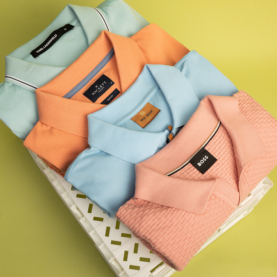 Gefaltete Poloshirts in Pastellfarben, Baumwolle, gestapelt auf Ablage