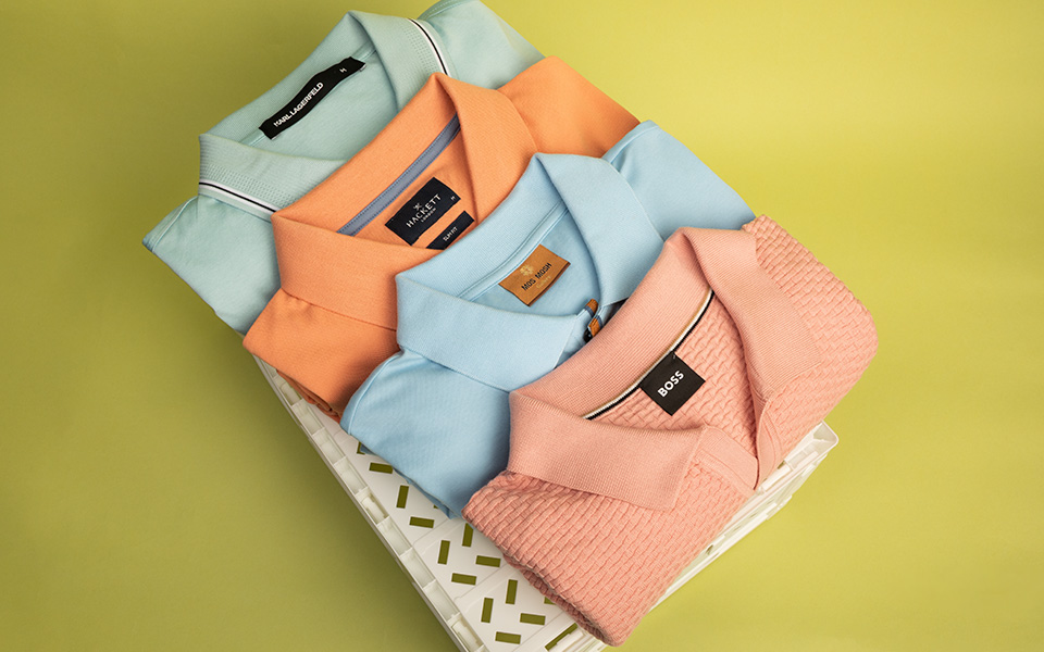 Gefaltete Poloshirts in Pastellfarben, Baumwolle, gestapelt auf Ablage