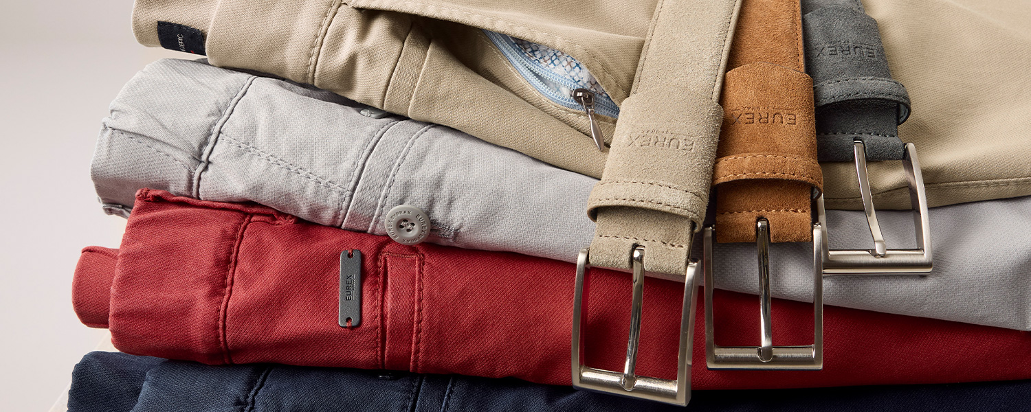 Stapel aus Chinos in Beige, Grau, Rot und Blau mit passenden Ledergürteln, Baumwollmischung