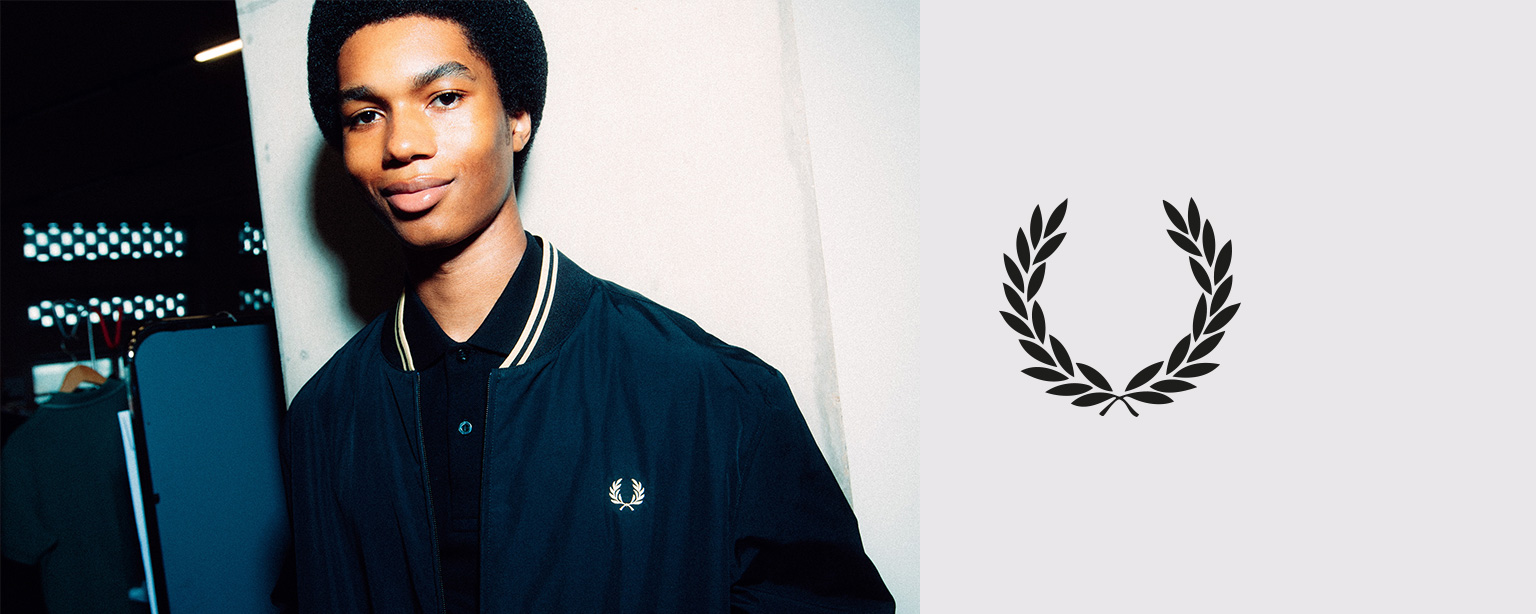 Mann in dunkelblauer Bomberjacke mit Logo, leger präsentiert