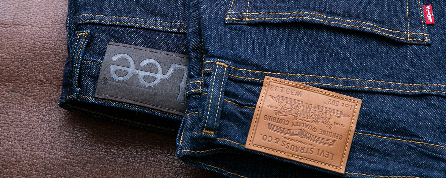 Grau-blauer Herrenblazer über gemustertem Pullover, getragen mit dunklen Jeans.