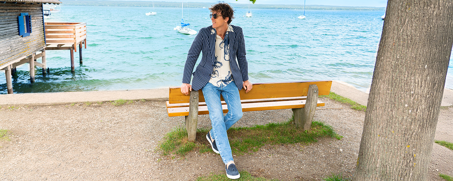 Steppjacke in Blau mit großkariertem Schal, getragen über weißem Hemd und blauer Jeans