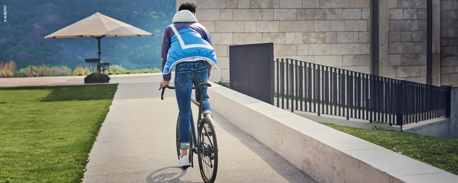 Sportlicher Look mit Jeans und Sneakern, kombiniert mit einer leichten Jacke – ideal für aktive Freizeitmomente wie eine Radtour.