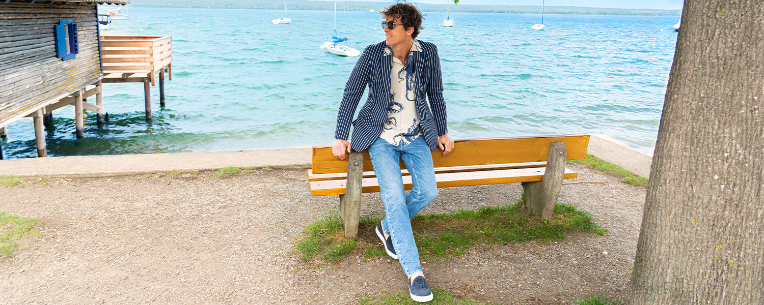 Blaue Five-Pocket-Denim im klassischen Schnitt, kombiniert mit Pullover, Jeansjacke und Mantel im legeren Outdoor-Look.