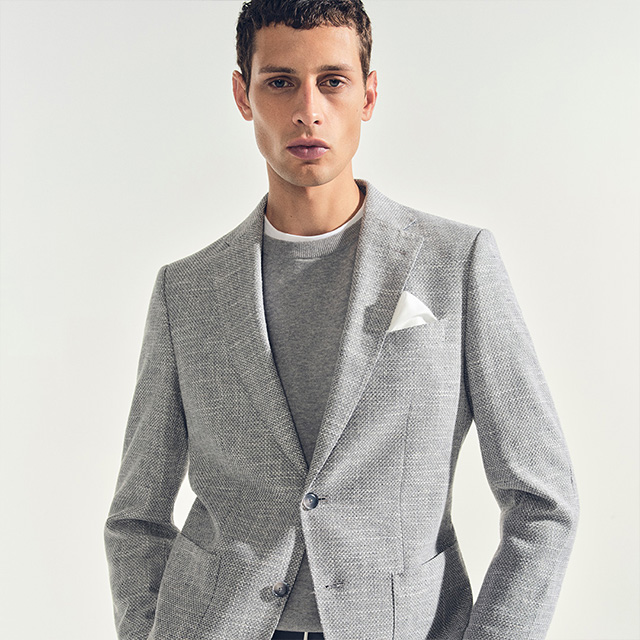 Hellgrauer Blazer aus Feinstrick, modern über grauem Pullover getragen, Detail: Einstecktuch