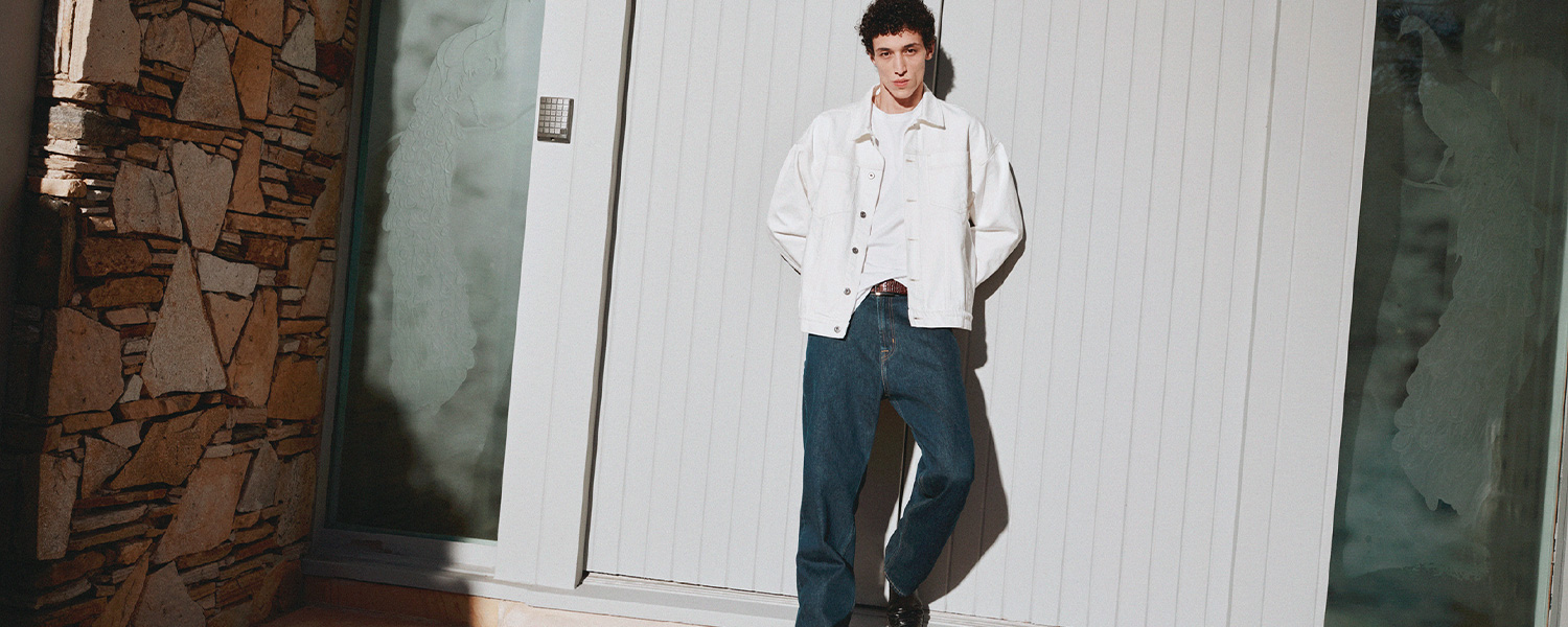 Mann in weißer Jeansjacke und blauer Jeans, leger getragen