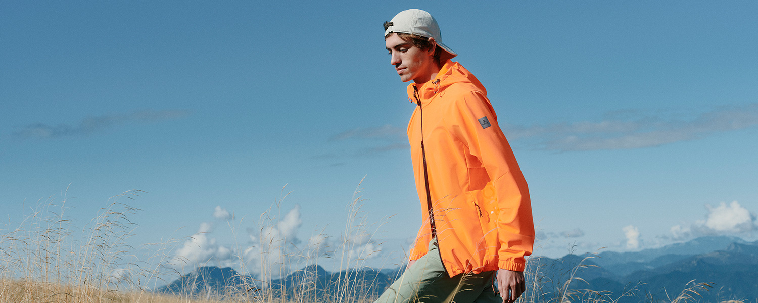 Orange Outdoor-Jacke aus Funktionsmaterial, stilvoll beim Wandern getragen