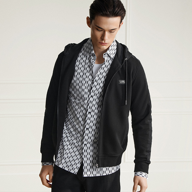 Mann in gemustertem Hemd und schwarzem Hoodie, lässig getragen