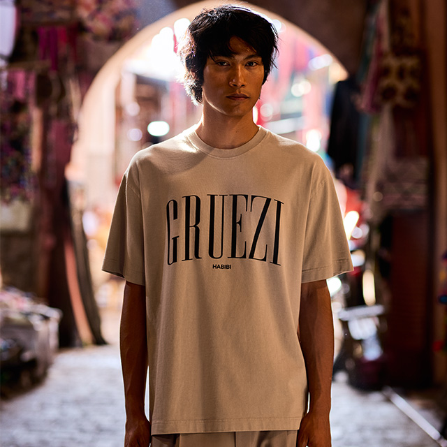 Hellbeiges T-Shirt mit Aufdruck, lässig getragen in urbaner Umgebung