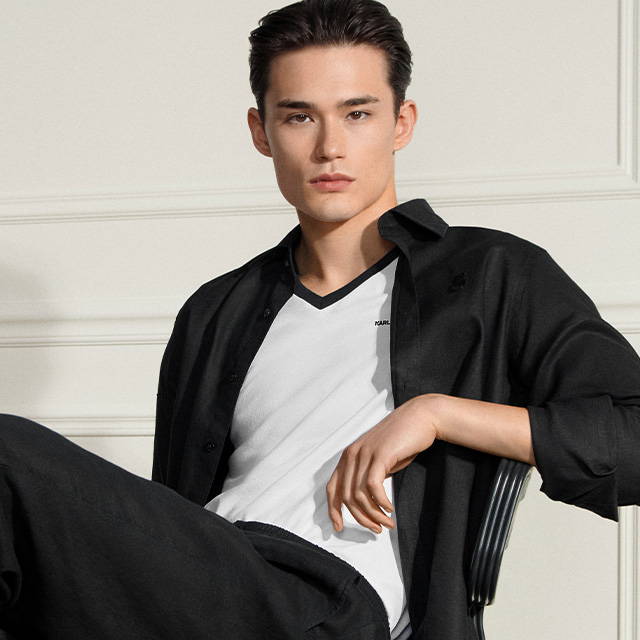 Schwarzes Freizeithemd aus Baumwolle, offen über weißem T-Shirt getragen