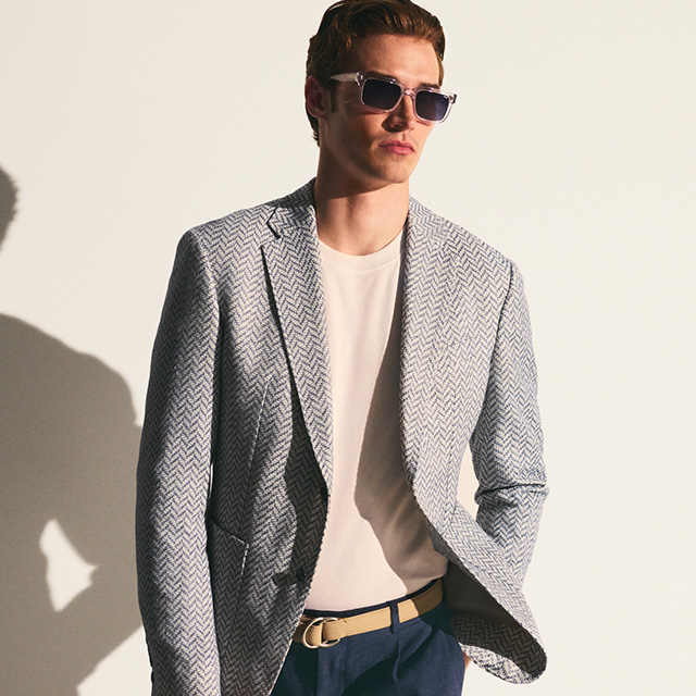 Herren Blazer mit Fischgrätmuster in Grau, lässig über beigem T-Shirt getragen