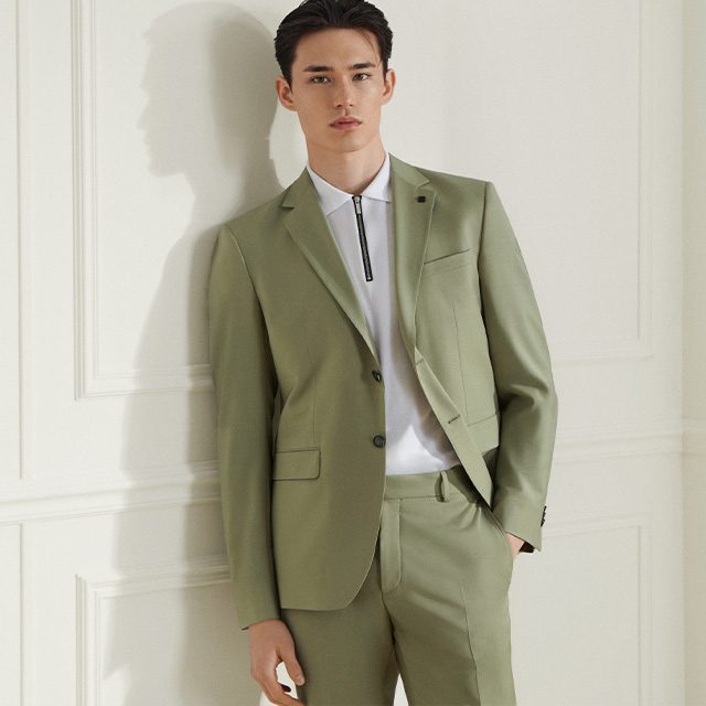 Grüner Anzug mit weißem Hemd, elegant getragen im Büroambiente