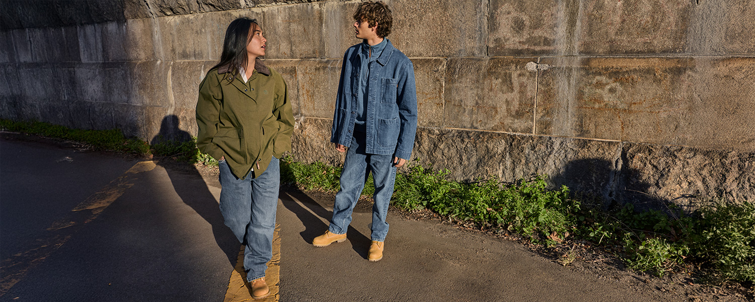 Zwei Personen in blue Jeans und Jacken aus Denim und Grün, lässig im Freien bei Sonnenschein