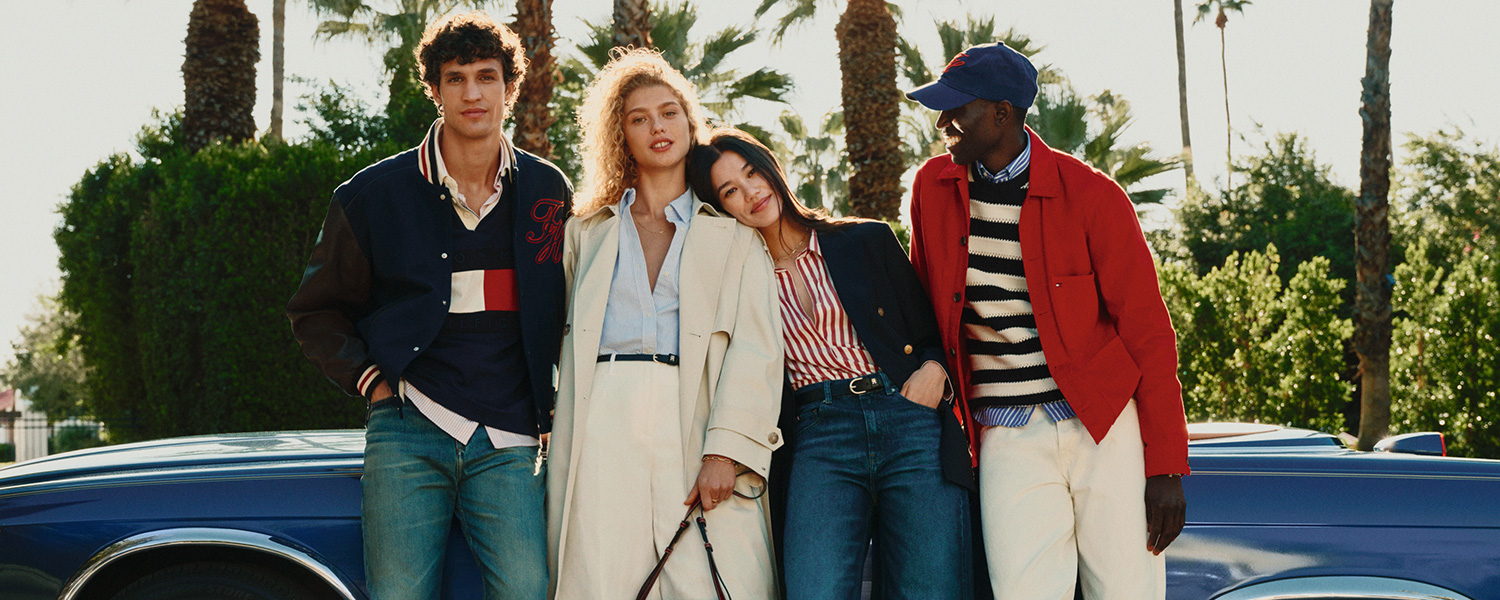 Gruppe in Freizeitkleidung, Herren in Jeans und Jacken neben Auto stehend, sonnige Umgebung