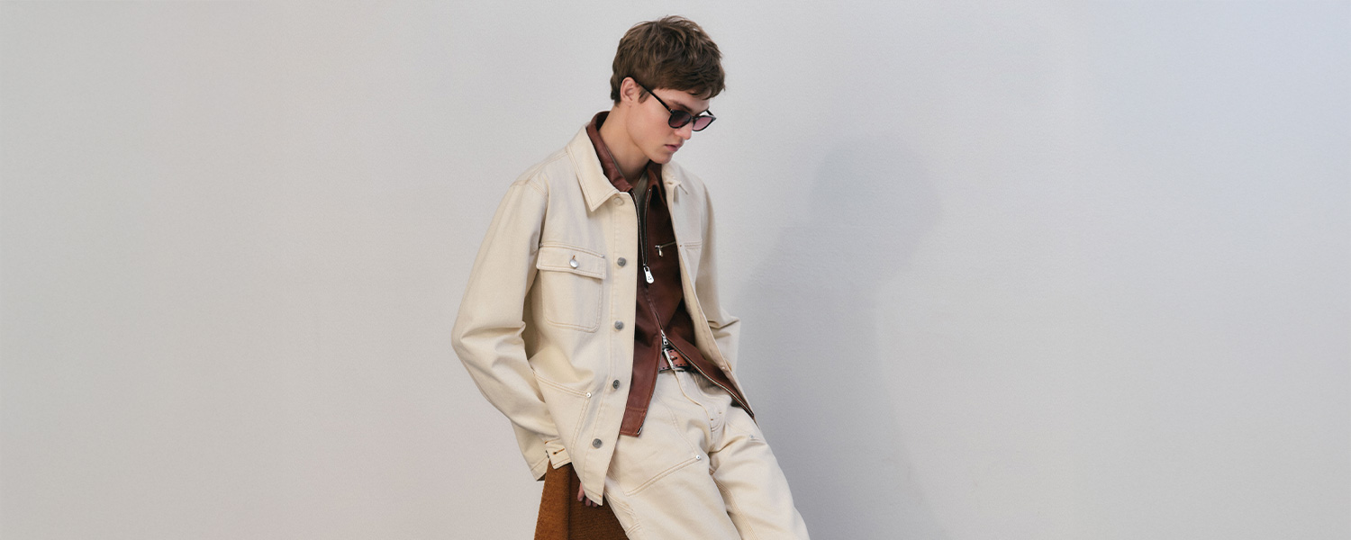 Hellbeige Jeansjacke über braunem Hemd, lässig getragen