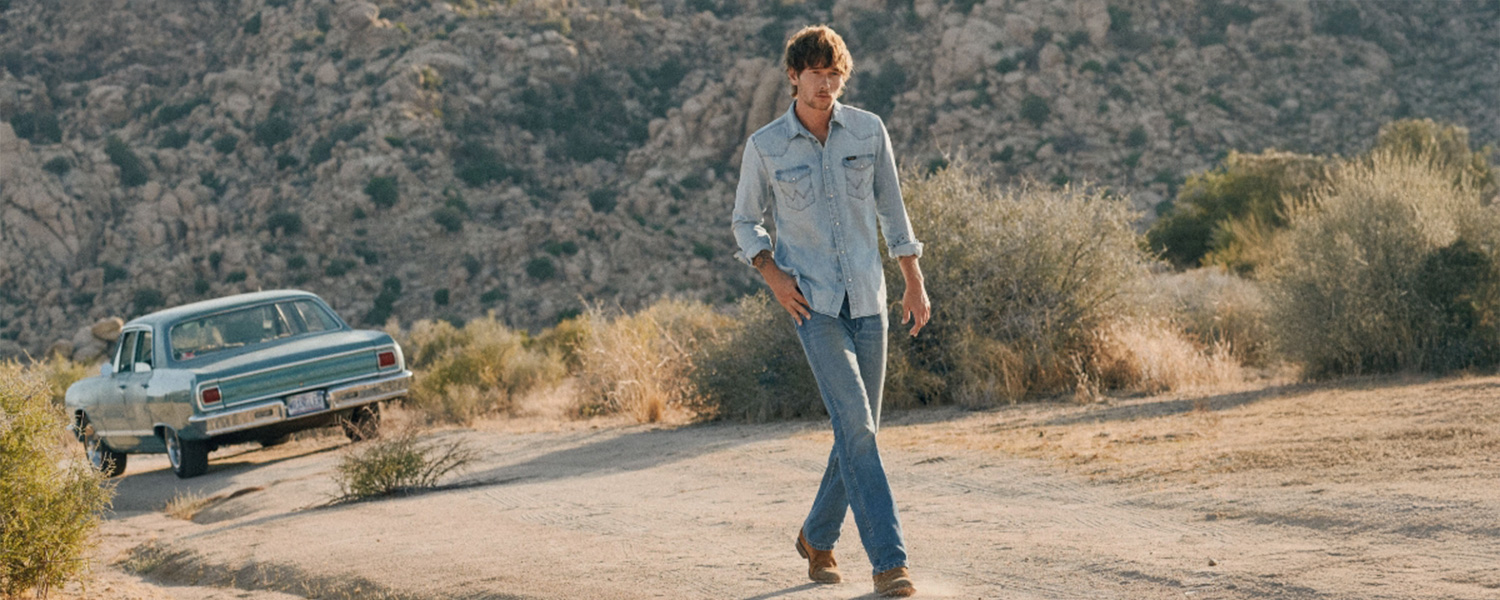 Mann in hellblauer Jeansjacke und Jeans, lässig in Wüstenlandschaft