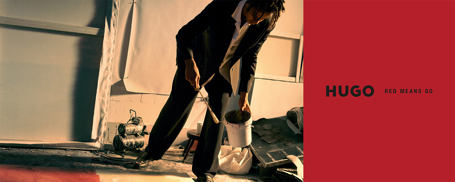 Mann in schwarzem Anzug und weißem Hemd mit Farbeimer in Künstleratelier