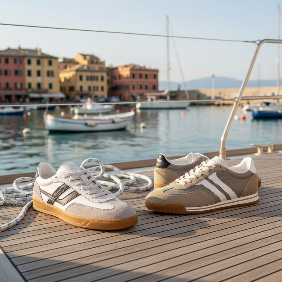 Zwei Paar Herren-Sneaker in Weiß und Beige auf Bootssteg, maritime Kulisse, betrachtet von der Seite