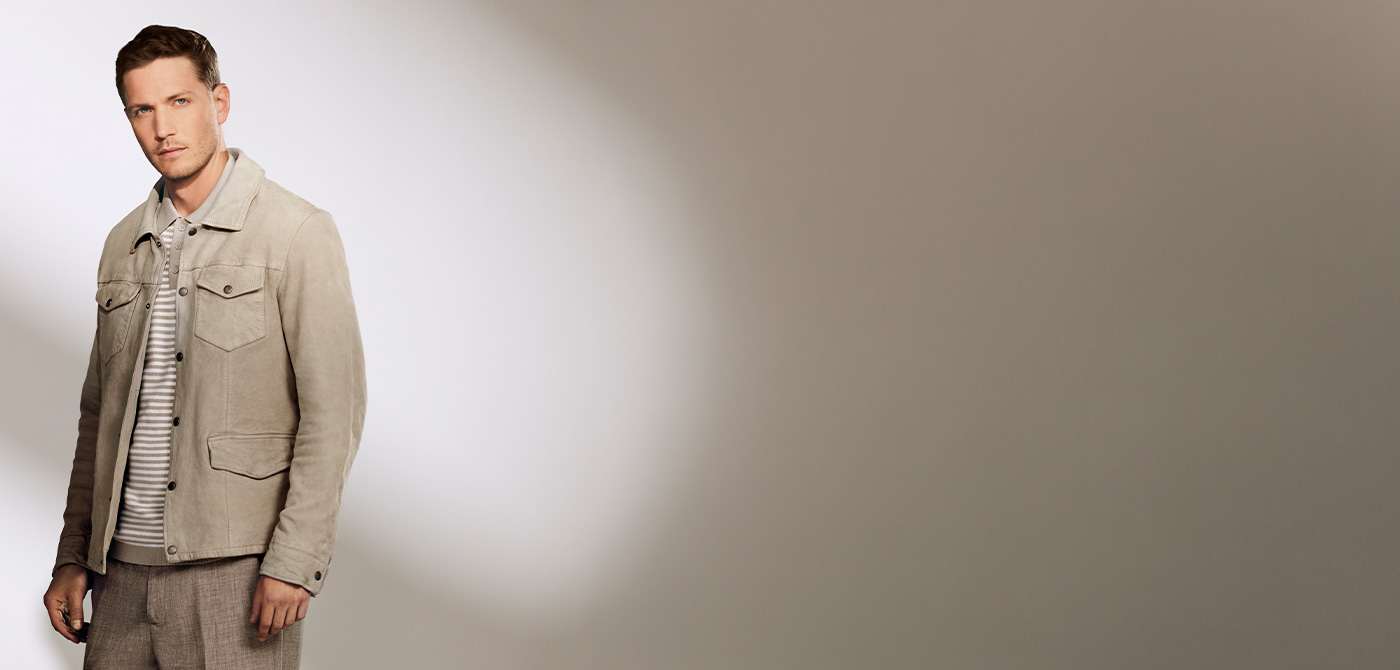 Hellgraue Wildlederjacke über gestreiftem Poloshirt, getragen von einem Mann, elegante Business-Casual-Kombination