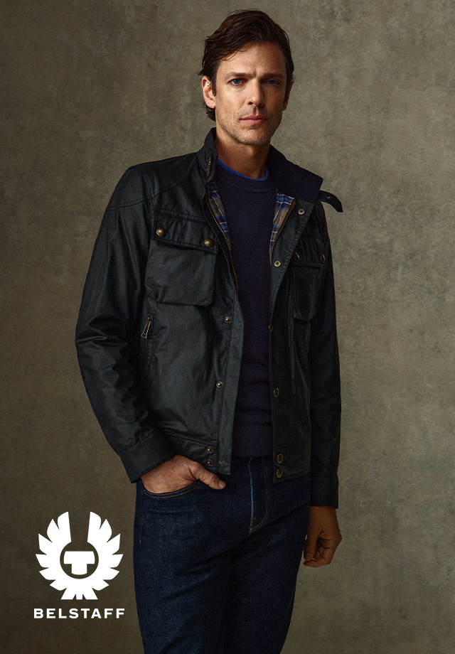 Dunkle Wachjacke mit Reißverschluss und Taschen, getragen über blau kariertem Hemd und Jeans