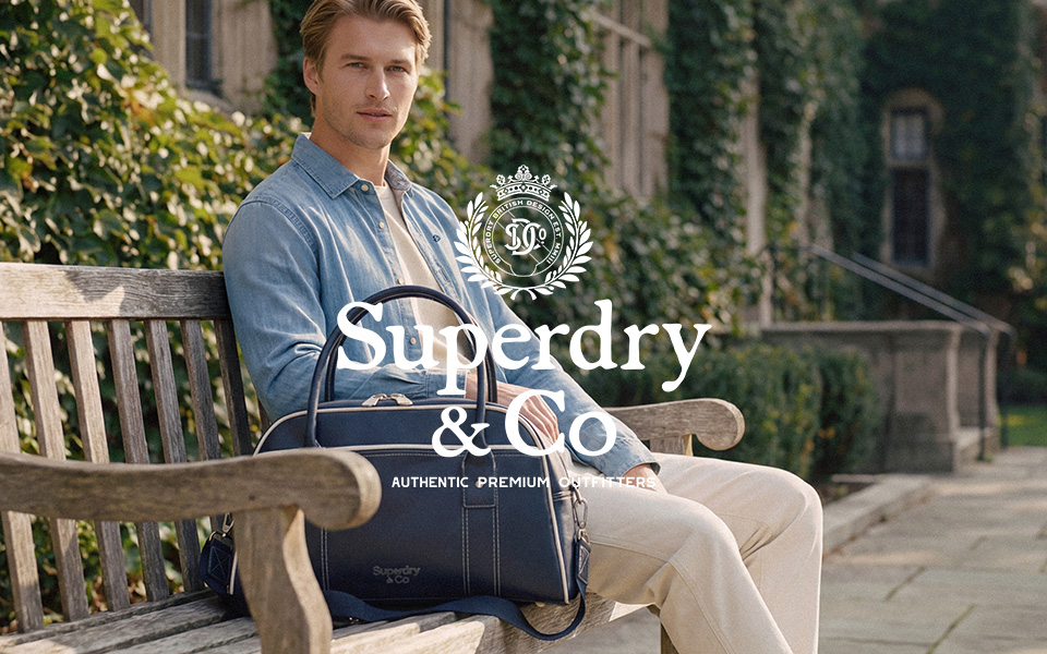 Herr in blauem Poloshirt und Marinejacke mit Fußball auf Campusgelände