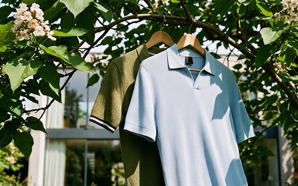 Hellblaues Poloshirt und olivgrünes Poloshirt mit Muster aus Baumwolle an Kleiderbügeln hängend