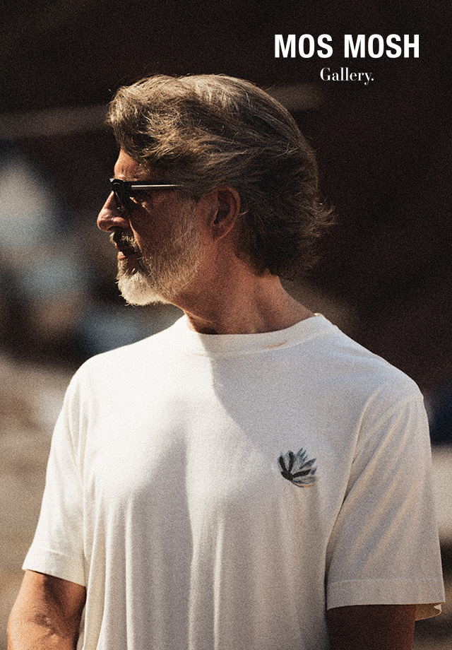 Herr in weißem T-Shirt mit dezentem Logo, lässig im Freien getragen