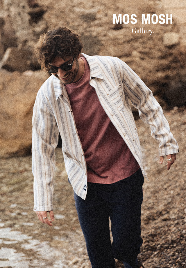 Mann in gestreifter Hemdjacke, helles Muster, am Strand spazierend