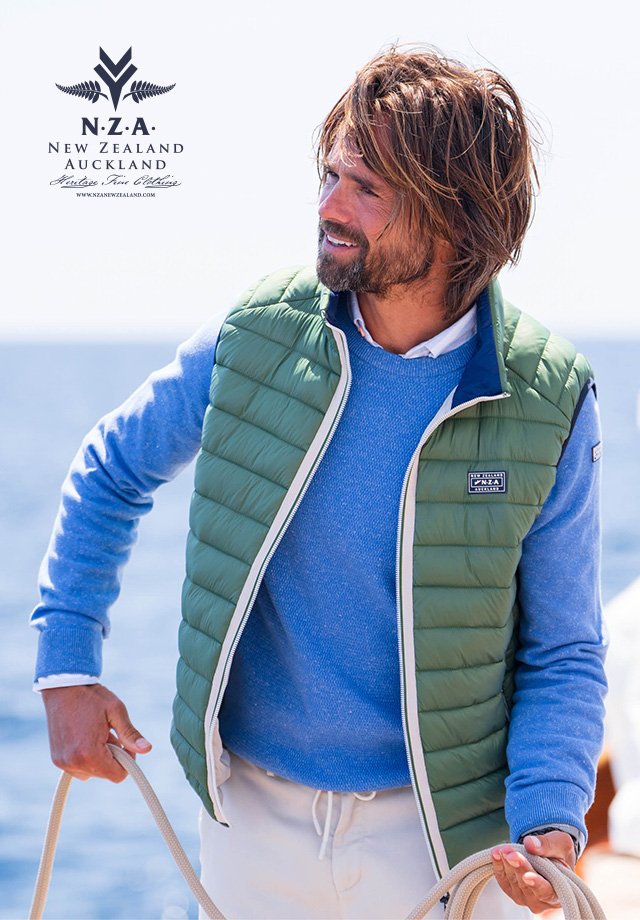 Mann in blauer Strickjacke mit grüner Steppweste bei Outdoor-Aktivität