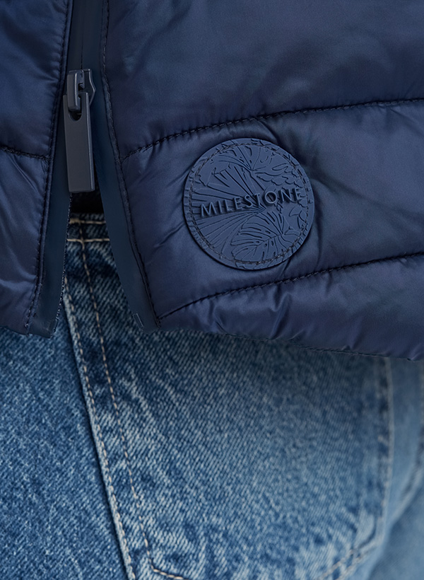 Dunkelblaue Steppweste aus Nylon, getragen über Jeans