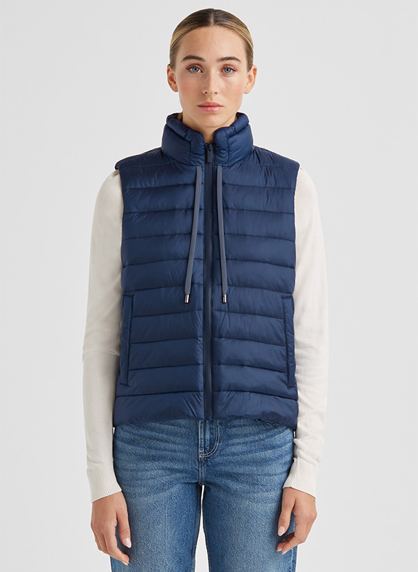 Dunkelblaue Steppweste aus Nylon, lässig über weißem Langarmshirt getragen